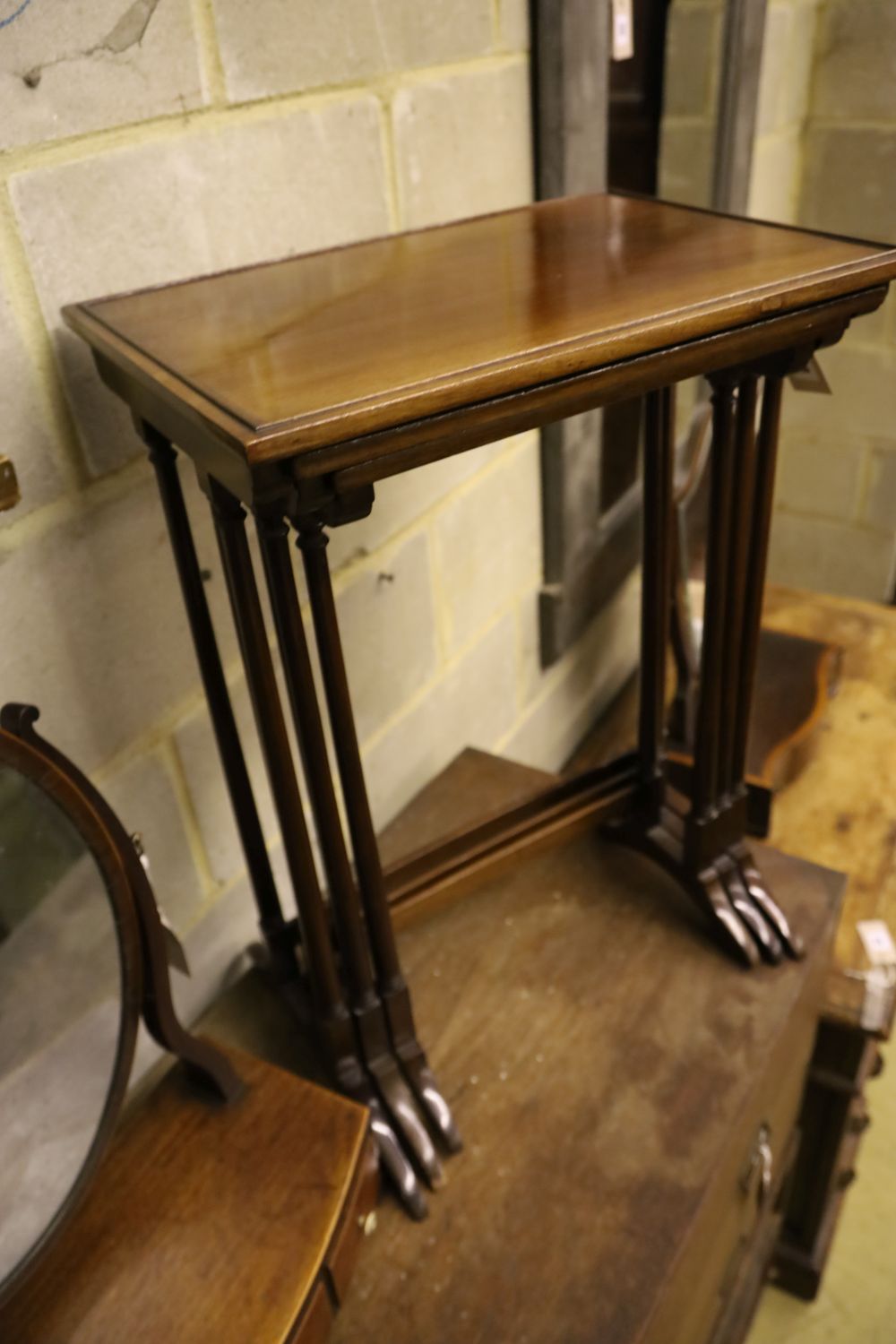 A nest of three mahogany tea tables, width 48cm depth 33cm height 67cm, and an oval swing frame toilet mirror with bow-fronted box base